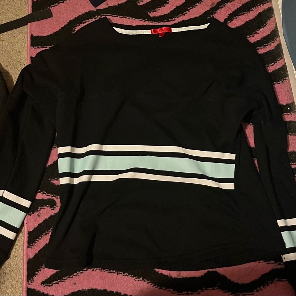 A black long sleeve shirt with white and mint green wording